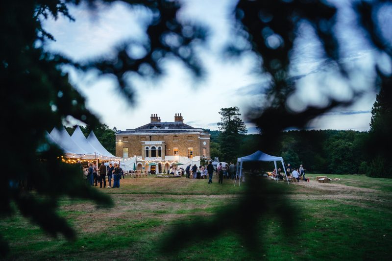 An image of Waverley Abbey, with marquees and string lights on the lawn outside